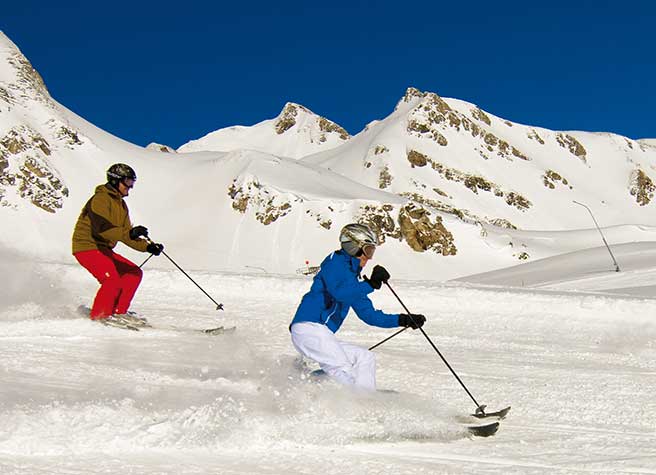 Ein Paar fährt Ski im unverspurten Tiefschnee